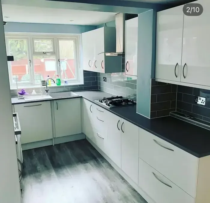 Compact white gloss kitchen refit with grey worktops and metro tiled splashback
