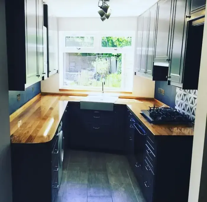 Navy shaker kitchen with solid oak worktops fitted by RenovationPlanltd
